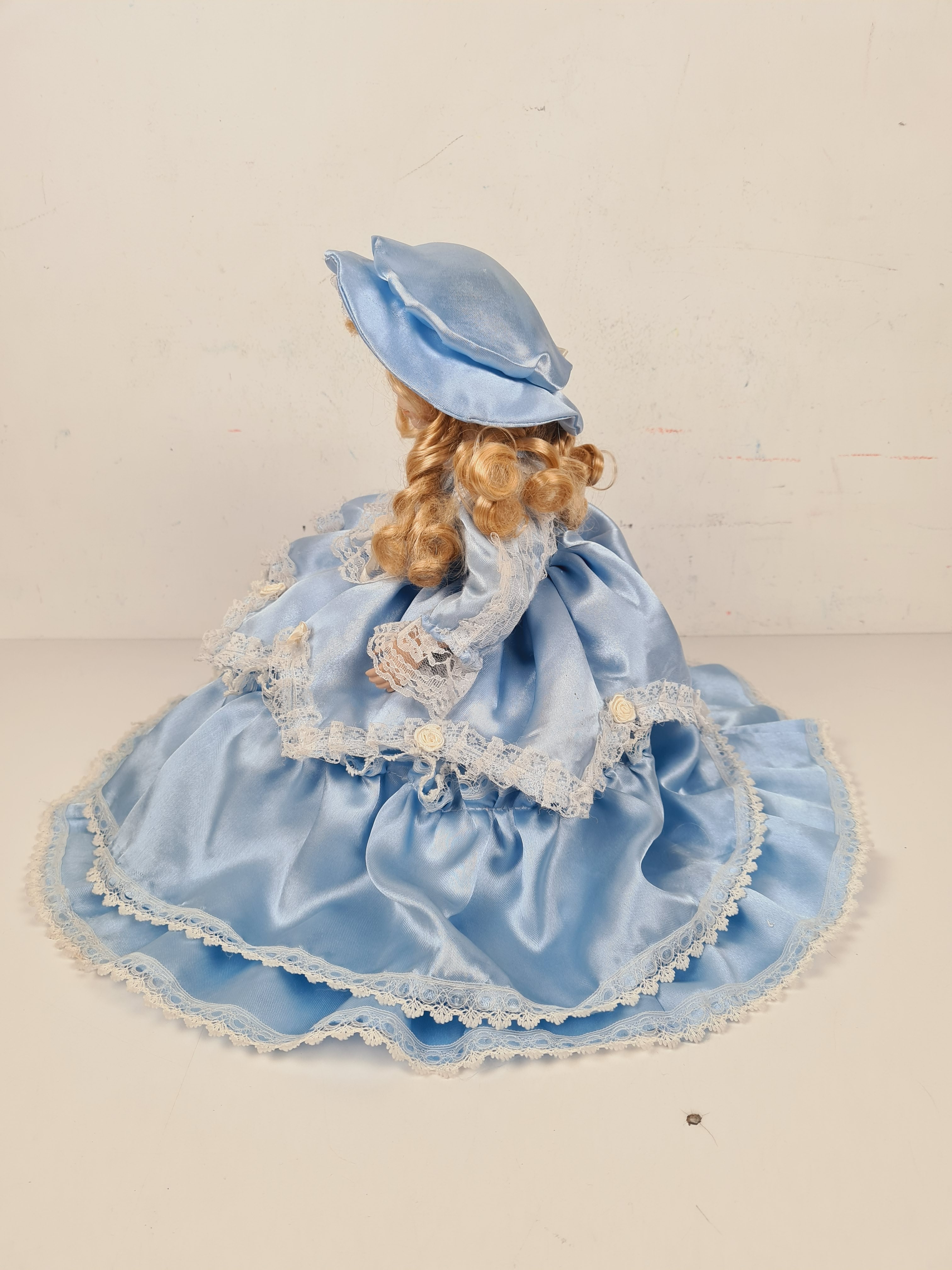 Voir photo 2 de Poupée - Poupée en porcelaine sur coussin avec une robe bleu - 33 cm Poupée - Poupée en porcelaine sur coussin avec une robe bleu - 33 cm Bon état - Vue 2 -